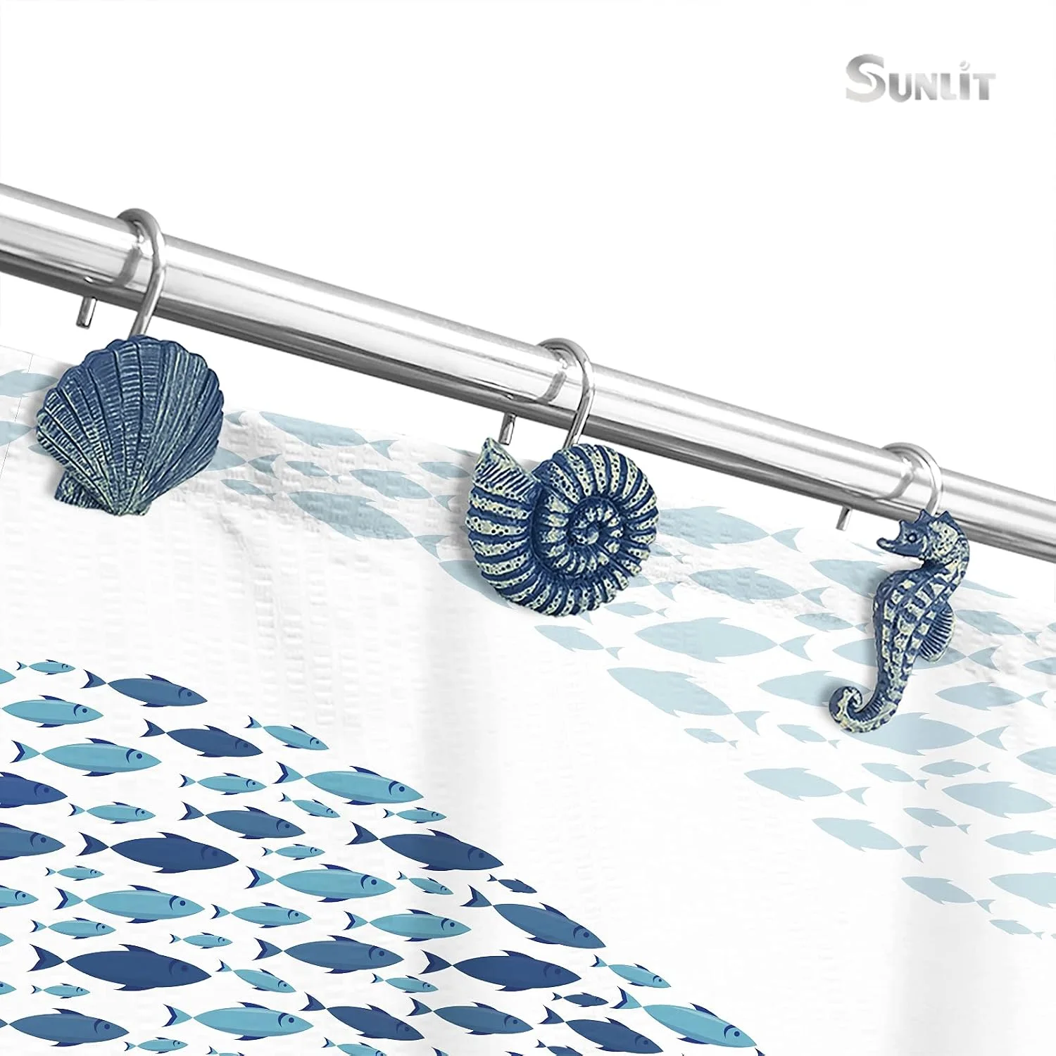 Sunlit seashell shower curtain hooks on a blue fish-print curtain